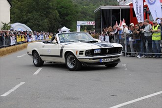 White Ford Mustang convertible at a classic car rally with spectators in the background, SOLITUDE