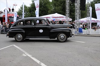 A black vintage car drives past a crowd at an event, SOLITUDE REVIVAL 2011, Stuttgart,