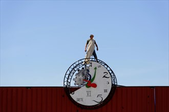 Art bazaar Marseille, A man stands on a large clock against the blue sky, Marseille, Departement