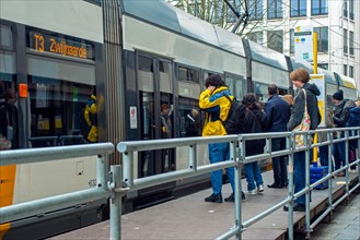 Commuters and shoppers boarding tram at tramstop of the Flemish transport company De Lijn in the