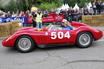 Driver in a red classic racing car with starting number 504 in front of a crowd, SOLITUDE REVIVAL
