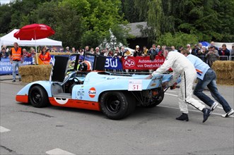 A Gulf racing car with the number 51 is supported by a helper at the start, SOLITUDE REVIVAL 2011,