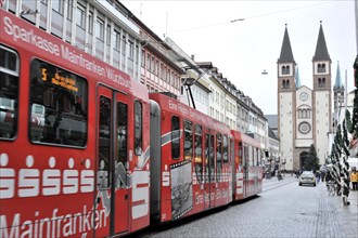 Wuerzburg, tram runs through Wuerzburg's city centre against a historic backdrop of church towers,