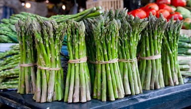 Bundles of green asparagus presented on a lively market stall, AI generated, AI generated