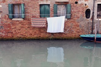 Freshly washed laundry hanging in front of a canal in Venice, Venice, Veneto, Italy, Europe