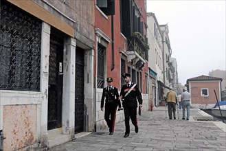 Island of Murano, Venice, Two policemen patrolling side by side on a street in Venice, Venice,