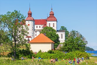 Lacko castle a famous swedish white baroque castle with sunbathing visitors at lake vanern,