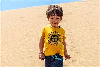 Portrait of tourist boy walking in the dunes of Maspalomas, Gran Canaria, Canary Islands
