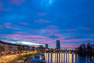 Sunrise on a riverbank in the centre of a big city. Spring with a view of the skyline of the