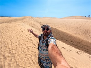 Selfie of a tourist with sunglasses and turban enjoying in the dunes of Maspalomas, Gran Canaria,