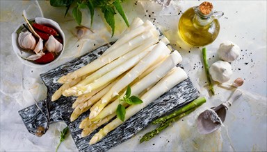 Rustic presentation of fresh white asparagus on a plate with olive oil and garlic, fresh white