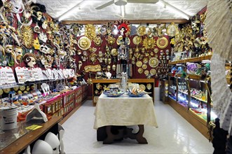 Burano, Burano Island, interior view of a shop full of traditional masks and decorated objects,