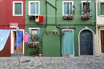Colourful houses, Burano, Burano Island, Colourful clothes hanging in front of a green house with