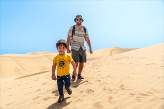 Father and son very happy in the dunes of Maspalomas, Gran Canaria, Canary Islands