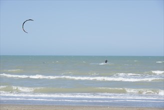 Kitesurfing Cutting Through the Waves in a Sunny Summer Day in Emilia Romagna, Rimini, Italy,