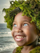 Delighted child with bright eyes and a nature-inspired headdress, moss growing and thriving,