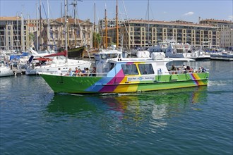 Marseille harbour, A colourful excursion boat in the harbour with city background, Marseille,