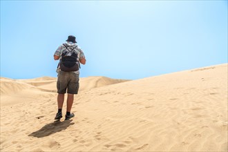 A man tourist enjoying in the dunes of Maspalomas, Gran Canaria, Canary Islands