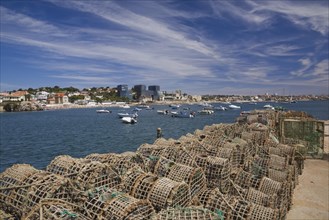 Commercial crab fishing cages and moored boats in the harbour at Cascais, Portugal, Europe
