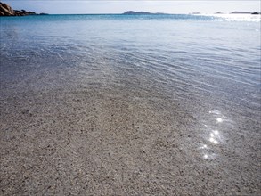 Waves reach the sandy beach, glittering sea, Capriccioli beach, Costa Smeralda, Sardinia, Italy,
