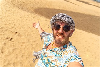 Selfie of a smiling tourist in the dunes of Maspalomas, Gran Canaria, Canary Islands