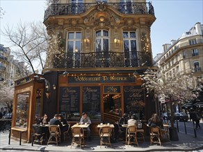 Menschen geniessen die Sonne in einem typischen Pariser Cafe an der Ecke einer Strasse, Lifestyle