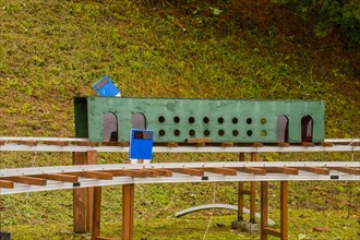 Close-up of a miniature railway track segment with circular holes and blue signs, in South Korea