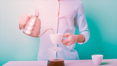 Bright image with a person pouring coffee from a gooseneck kettle into a filter on turquoise