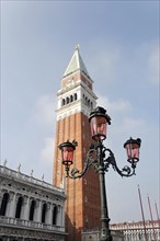 The Campanile in Venice rises behind a classic street lamp, Venice, Veneto, Italy, Europe