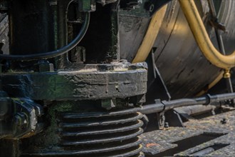 Close-up view of train's hydraulic machinery showcasing metallic textures and technical components,