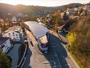 Aerial view of a shopping centre with parked cars in a residential area at sunset, Calw, Black