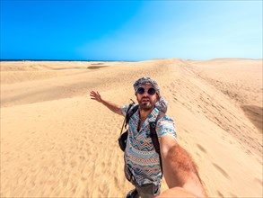 Selfie of a tourist with sunglasses enjoying in the dunes of Maspalomas, Gran Canaria, Canary