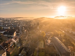 Sunrise over a fog-covered small town with a striking church tower, Gechingen, Black Forest,