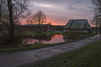 Evening atmosphere with stables and fire pond on an old farm from 1921, Othenstiorf,