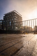 Ibis Styles Hotel, Modern architecture with reflection in a puddle, captured in daylight, sunrise,