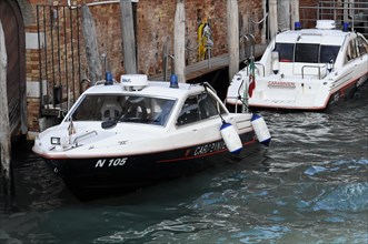 Boats of the Italian water police Carabinieri sailing through a canal in Venice, Venice, Veneto,
