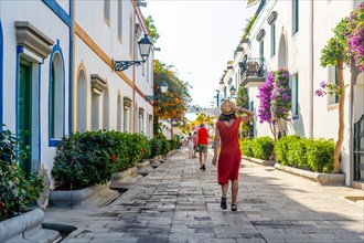 A woman walking in the port of the coastal town Mogan in the south of Gran Canaria. Spain