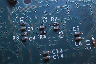 Close-up of blue lighted electronic computer circuit board with microchips and lines, Studio