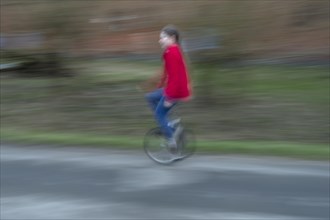 Girl, 10 years old, riding a unicycle, motion blur, Mecklenburg-Vorpommern, Germany, Europe