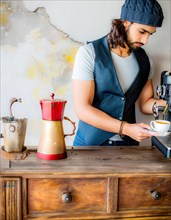 A barista prepares espresso at a vintage coffee machine on a rustic wooden counter, Vertical aspect