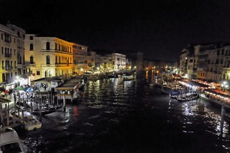Night scene of a busy Venetian canal with reflections, Venice, Veneto, Italy, Europe