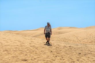 Tourist man with turban in summer walking in the dunes of Maspalomas, Gran Canaria, Canary Islands