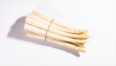 A bunch of white asparagus lies on a white background with shadows, AI generated, AI generated