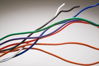 Close-up of orange, red, green, blue, purple, white and black shielded electrical copper wires on