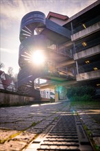 Rays of sunlight fall through a spiral staircase attached to a building, Calw, Black Forest,