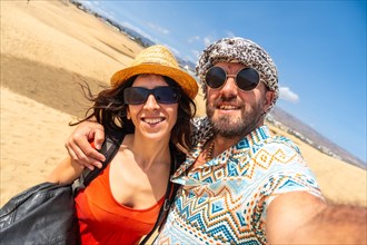A happy couple on summer holidays in the dunes of Maspalomas, Gran Canaria, Canary Islands