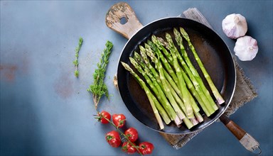 Rustic presentation of green asparagus surrounded by fresh tomatoes and garlic, green asparagus,