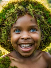 Cheerful child with natural hair adorned with moss and glowing blue eyes, earth day concept, AI