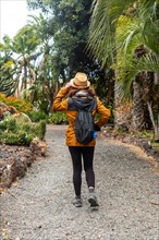 A tourist woman walking in a botanical garden. Tropical plants concept