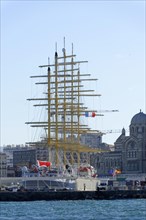 Marseille in the morning, Historic tall ship in the harbour in front of the city skyline under a